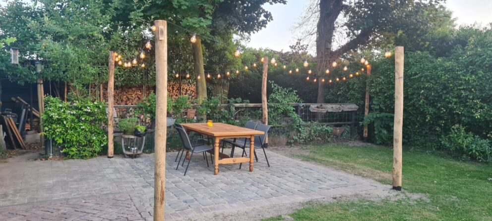 Kastanje paal 300 cm lang, diameter 13/16 cm bij een terras gebruikt om een lichtsnoer aan te bevestigen