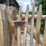 Frans schapenhek 100 cm hoog, latafstand 4 cm met raamwerkpoort kastanje 100Bx100H (cm) en kastanje paal 175 cm lang, diam. 10/12 cm met close-up houten logo Adéquat