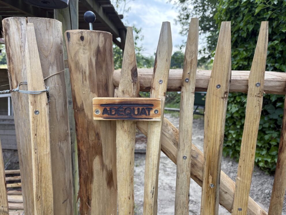Frans schapenhek 100 cm hoog, latafstand 4 cm met raamwerkpoort kastanje 100Bx100H (cm) en kastanje paal 175 cm lang, diam. 10/12 cm met close-up houten logo Adéquat
