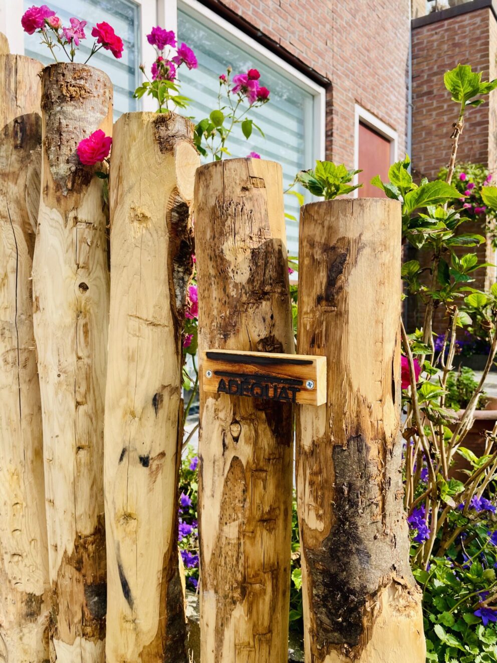 Creatieve afscheiding met kastanje palen in een voortuin met bloemen, palen in de maten 120, 150/160, 175 en 200 cm lang, diameter 10/12 cm