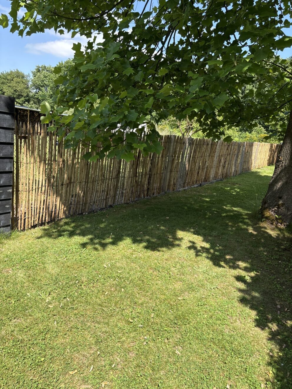 Frans schapenhek kastanje 150 cm hoog, latafstand 2 cm als afrastering in een groene tuin