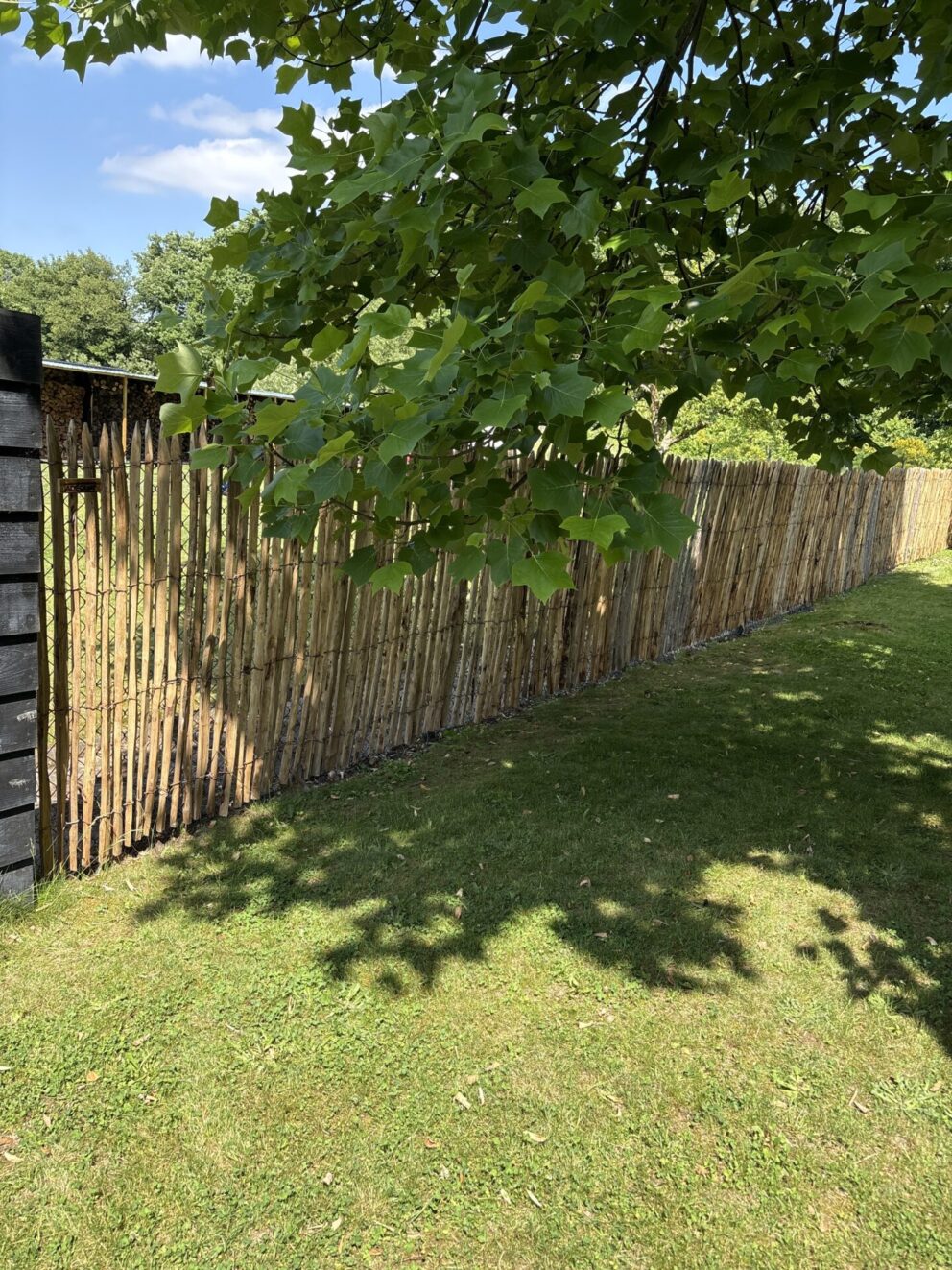 Frans schapenhek kastanje 150 cm hoog, latafstand 2 cm als afrastering in een groene tuin
