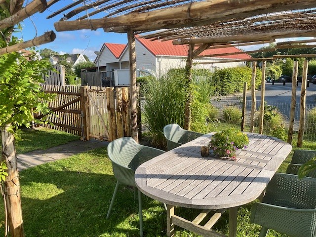 Pergola van kastanjepalen, afgewerkt met een schapenhek kastanje van 150 cm hoog (latafstand 10 cm) en schapenhek poort op maat,120 hoog x 230 breed (cm) met looppoortje