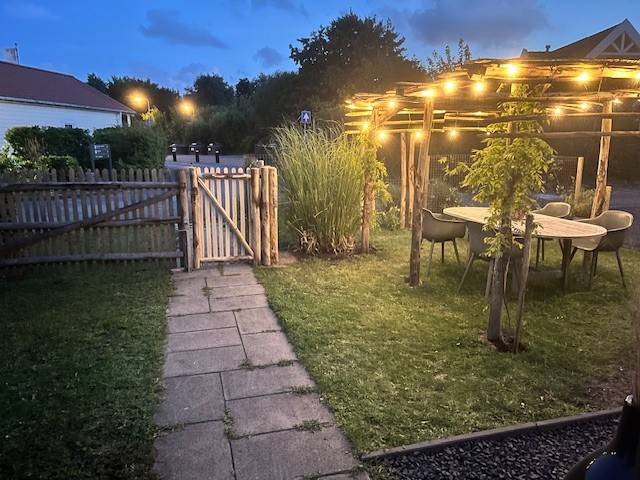 Pergola van kastanjepalen, afgewerkt met een schapenhek kastanje van 150 cm hoog (latafstand 10 cm) en schapenhek poort op maat,120 hoog x 230 breed (cm) met looppoortje