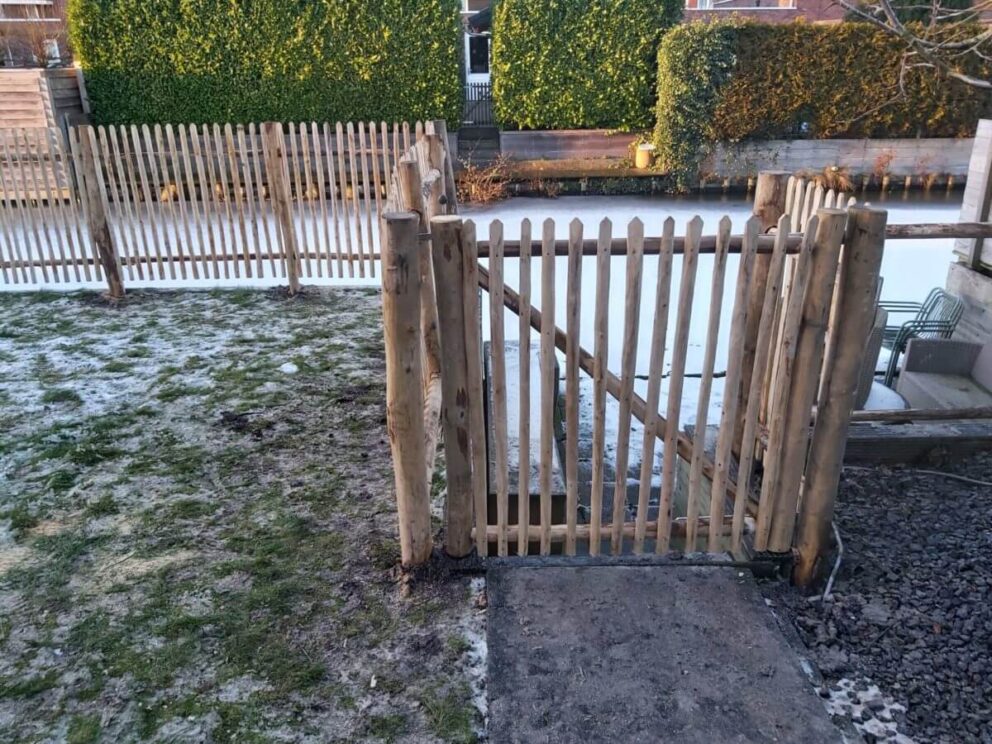 Een rondhoutpoort voorzien van halfronde kastanje latten