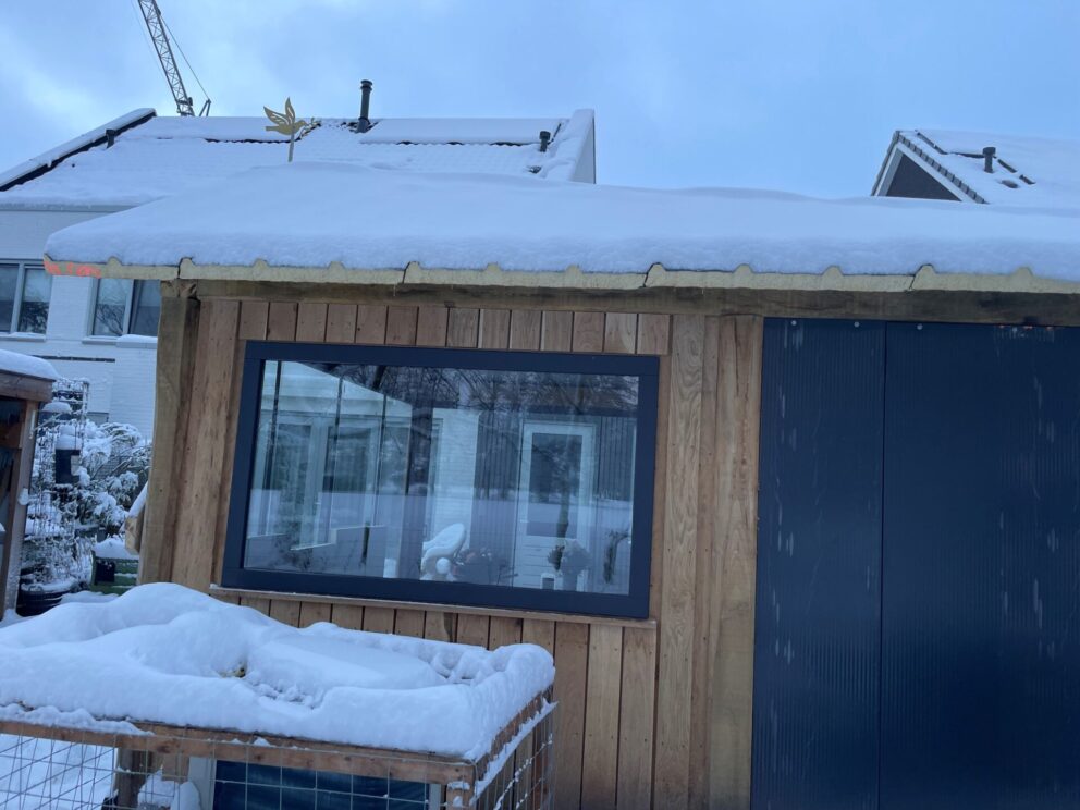 Bouw huisje van rustiek bezaagde balken, in de sneeuw