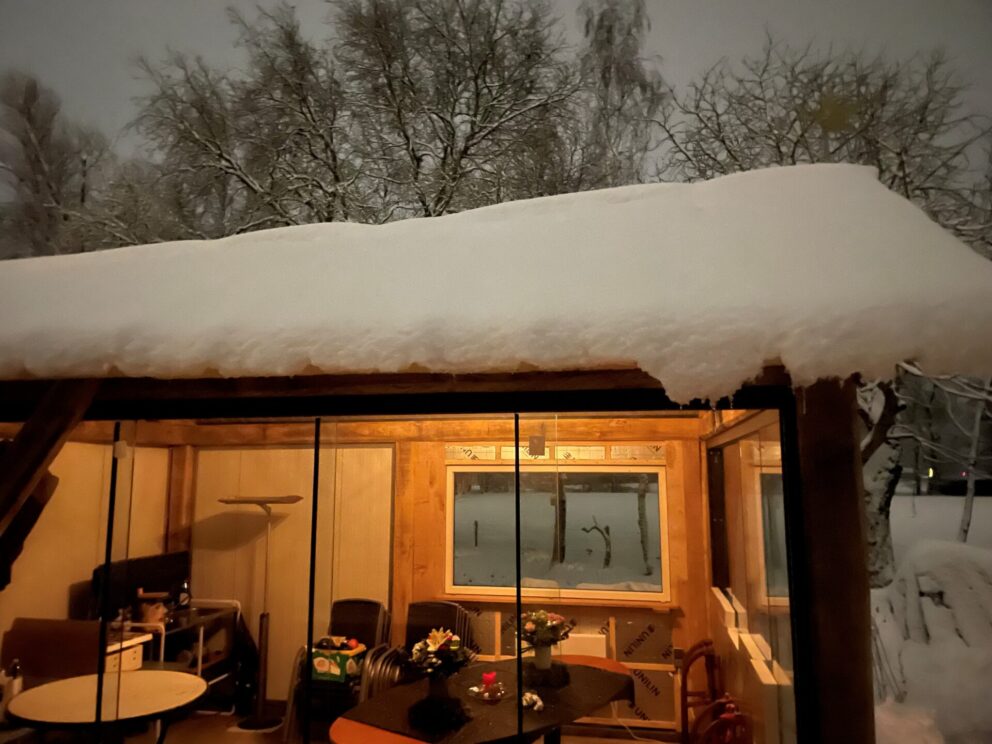 Bouw huisje van rustiek bezaagde balken, in de sneeuw