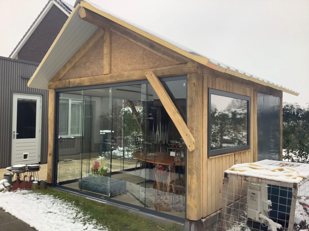 Bouw huisje van rustiek bezaagde balken, in de sneeuw