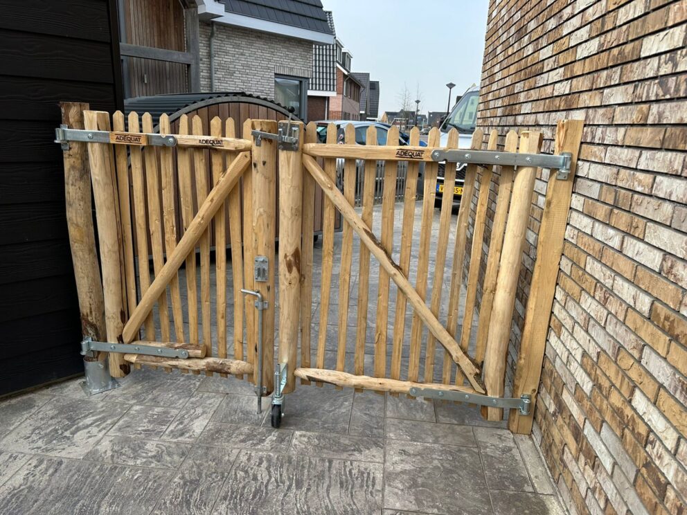Schapenhek poort kastanje dubbel, 80 cm breed x 120 cm hoog (rechts), schapenhek poort kastanje dubbel, 100 cm breed x 120 cm hoog (links), plantpaal met bodemhuls, bodemhuls met grondplaat 10 cm, daarop aangepaste poortpaal en een afgevlakte poortpaal voor bevestiging tegen de muur