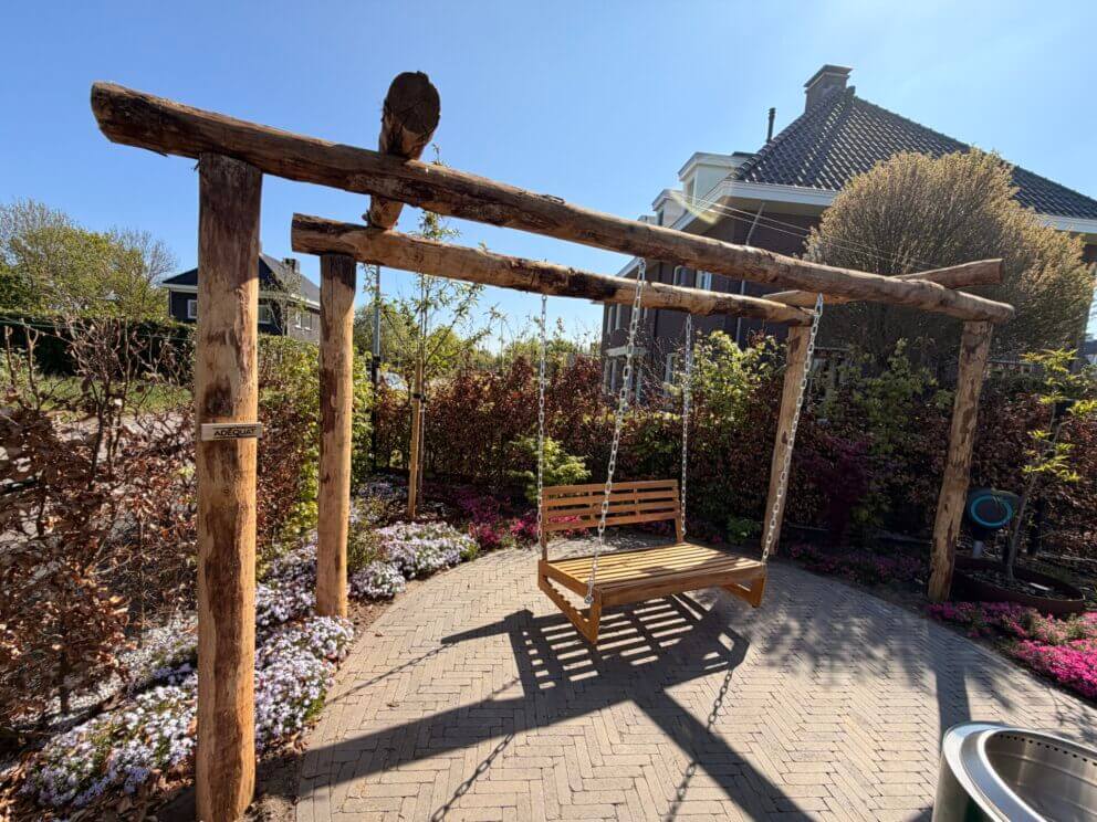 Prachtige pergola met schommel gemaakt van kastanje palen