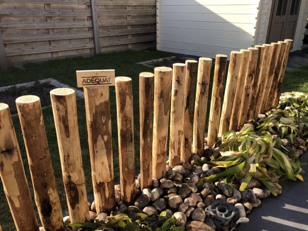 Palenwand als afscheidingselement in de tuin gemaakt van kastanjepalen van 7/9 cm